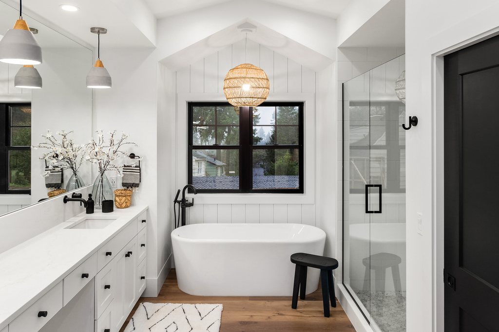 Freestanding soaking tub set beneath a picture window, a Jones Quality Remodeling bathroom